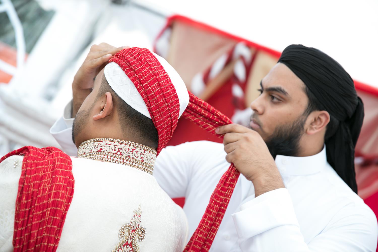 Muslim Wedding Photography of groom putting on hat by MAKSAM Photography