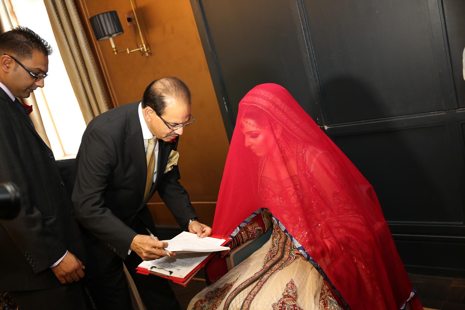 Wedding Photography of Bride signing certificate at her Asian Wedding by MAKSAM Photography London