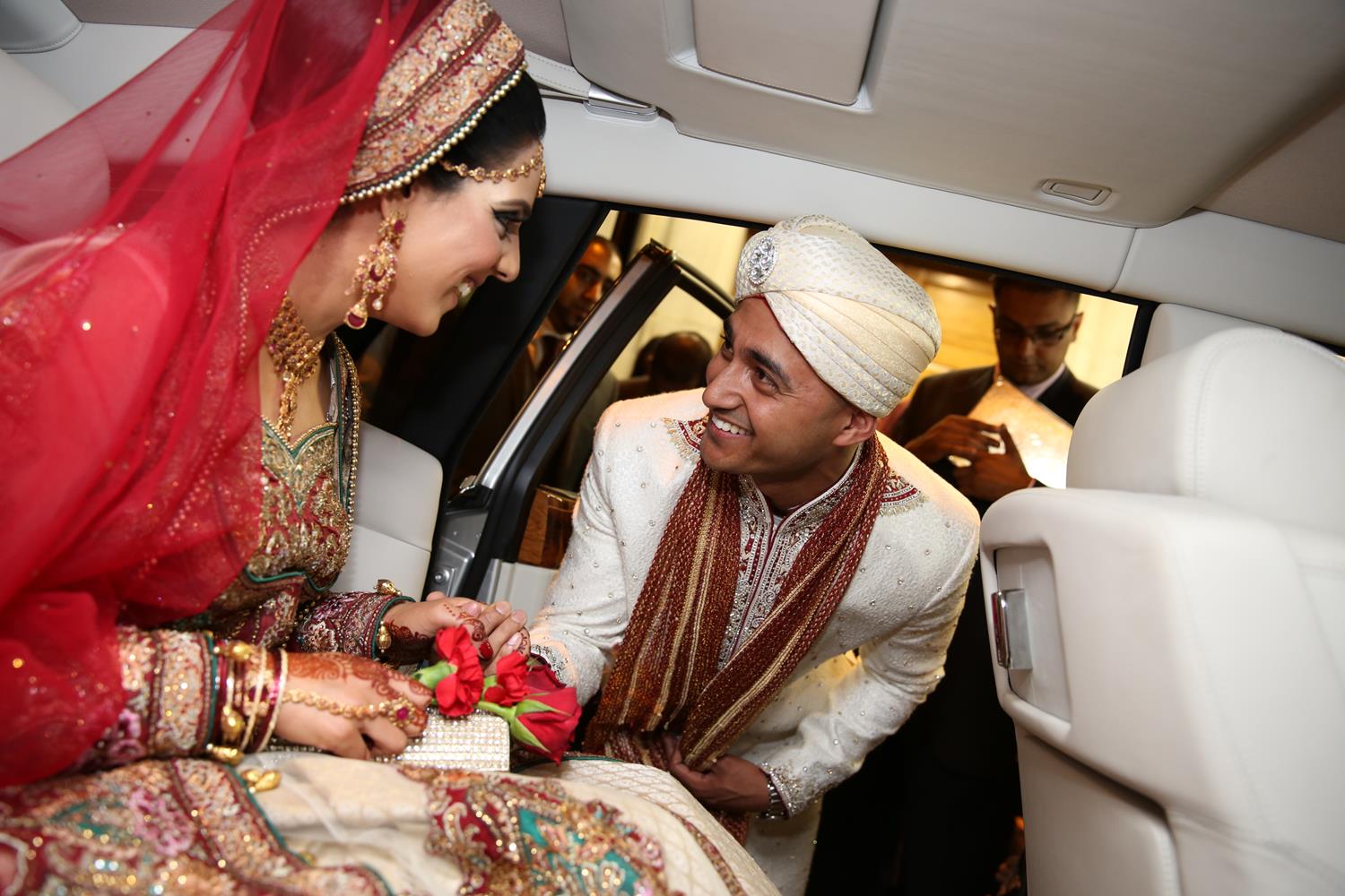 Wedding Photography of groom greeting bridge in car arriving at their Indian Wedding by MAKSAM Photography London