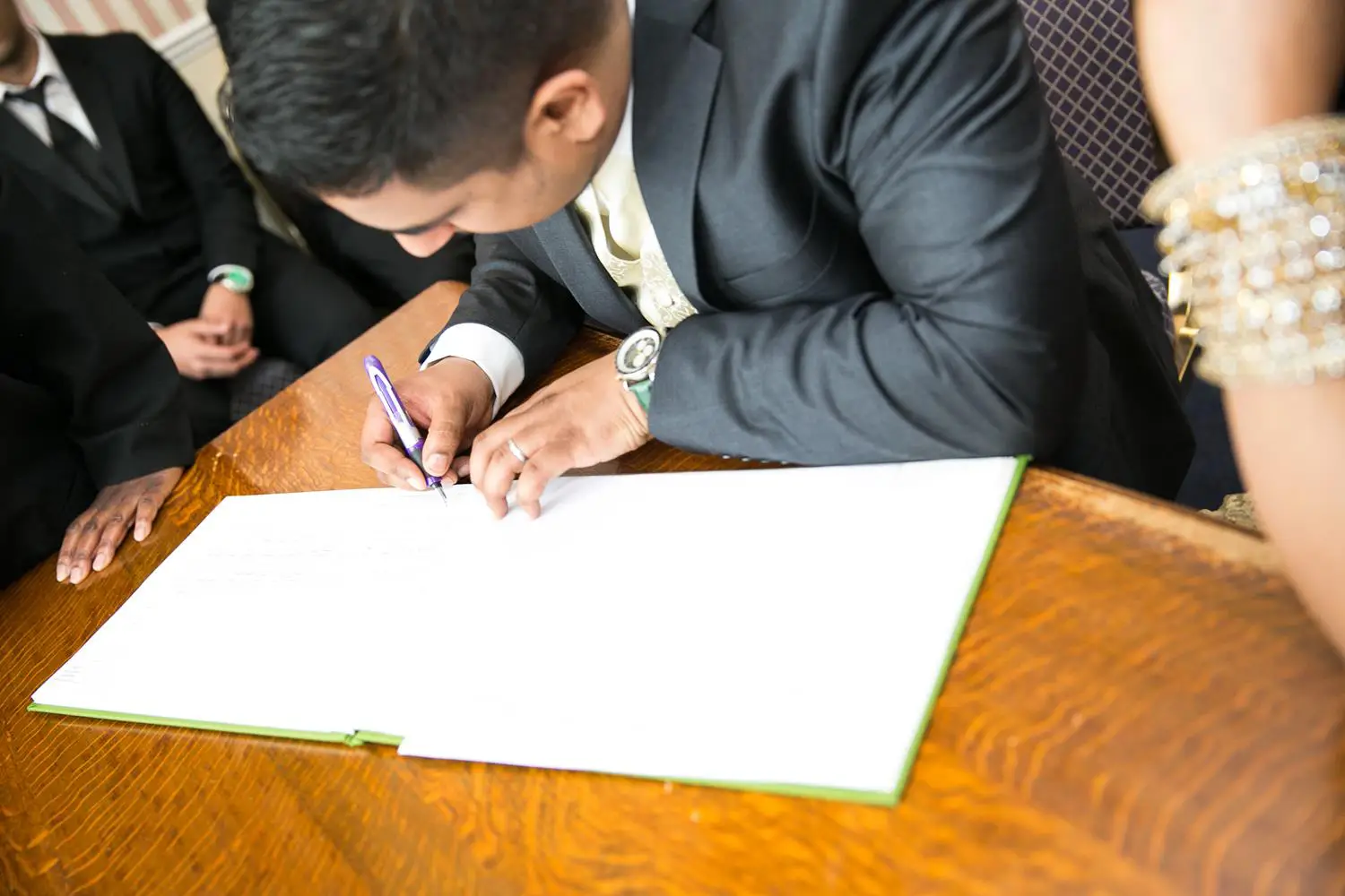 Registry Photography of groom signing book at registry office by MAKSAM Photography