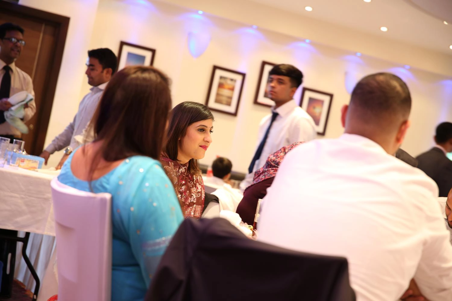 People sitting down at an Indian Wedding Dinner by MAKSAM Photography